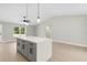 Modern kitchen featuring a central island with gray cabinets, quartz countertop, and pendant lighting at 13254 Sw 30Th Terrace Rd, Ocala, FL 34473
