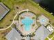 Aerial view of community pool with lounge chairs, lush landscaping, and adjacent clubhouse, perfect for relaxation at 13330 Panama Beach Ct, Orlando, FL 32827