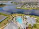 A high aerial showcases the pool, lounge area, and lakefront property of this serene community at 13330 Panama Beach Ct, Orlando, FL 32827