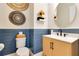 Stylish half bathroom featuring blue wainscoting, a modern vanity, and decorative wall art at 13330 Panama Beach Ct, Orlando, FL 32827