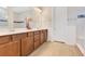 Bathroom featuring double vanity with shaker cabinets and tiled shower with transom window at 13330 Panama Beach Ct, Orlando, FL 32827