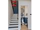 View of stairs and a half bathroom with blue wainscoting and decorative wall hangings at 13330 Panama Beach Ct, Orlando, FL 32827