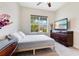 Bedroom with gray carpet, a queen bed, dresser, and a large window at 13330 Panama Beach Ct, Orlando, FL 32827