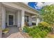 Covered home entrance features a gray door, porch seating and a landscaped garden at 13330 Panama Beach Ct, Orlando, FL 32827