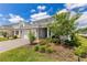 Eye-level exterior view of a two-story home featuring a stone veneer and brick driveway at 13330 Panama Beach Ct, Orlando, FL 32827