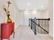 Bright hallway featuring black wrought iron staircase and a vibrant red accent cabinet at 13330 Panama Beach Ct, Orlando, FL 32827
