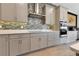 Modern kitchen featuring gray cabinets, stainless steel appliances, and stylish backsplash, offering a sleek and functional space at 13330 Panama Beach Ct, Orlando, FL 32827