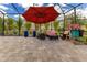 View of the outdoor patio featuring ample seating, a shade umbrella and lush potted plants at 13330 Panama Beach Ct, Orlando, FL 32827