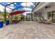 Relaxing screened-in patio with ample seating, large paver stones, and space for outdoor dining at 13330 Panama Beach Ct, Orlando, FL 32827