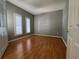 Light gray bedroom with wood floor features white trim and shuttered windows at 1432 Stargazer Ter, Sanford, FL 32771