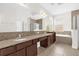 Bathroom featuring double sinks with granite countertop, soaking tub, and a walk-in shower at 16780 Meadows St, Clermont, FL 34714