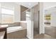 Bathroom with a jacuzzi tub and shower separated by glass enclosure at 16780 Meadows St, Clermont, FL 34714