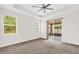 Spacious bedroom featuring carpet floors, a ceiling fan, and sliding glass doors to the lanai at 16780 Meadows St, Clermont, FL 34714