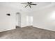 Neutral bedroom with a tray ceiling, ceiling fan, and gray carpet at 16780 Meadows St, Clermont, FL 34714