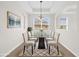 Elegant dining room showcases neutral decor, a modern light fixture, and a glass-top table with seating for six at 16780 Meadows St, Clermont, FL 34714