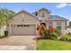 Charming home featuring a two-car garage, brick driveway, and lush landscaping at 16780 Meadows St, Clermont, FL 34714