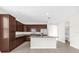 Well-equipped kitchen with stainless appliances, an island with breakfast bar, granite countertops, and dark wood cabinets at 16780 Meadows St, Clermont, FL 34714