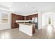 Modern kitchen featuring a granite island, stainless steel appliances, and dark wood cabinets at 16780 Meadows St, Clermont, FL 34714