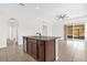 Spacious kitchen island with dark wood cabinets, granite countertops, and a stainless steel dishwasher and sink at 16780 Meadows St, Clermont, FL 34714