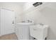Bright laundry room featuring a washing machine, sink, overhead rack, and a white paneled door at 16780 Meadows St, Clermont, FL 34714