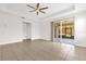 Open living room with tile floors, ceiling fan, and sliding glass doors to the screened patio at 16780 Meadows St, Clermont, FL 34714