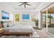 Bright and airy main bedroom with a tray ceiling, neutral decor, large windows, and sliding glass doors at 16780 Meadows St, Clermont, FL 34714