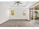 Spacious main bedroom with a ceiling fan, sliding glass door, and plush carpeting at 16780 Meadows St, Clermont, FL 34714