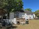 Exterior view of home featuring damaged white siding and overgrown lawn at 1708 W 16Th St, Sanford, FL 32771