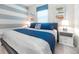 Bright bedroom featuring horizontal striped accent wall, and a plush queen bed with bedside tables at 1820 Summer Dr, Davenport, FL 33897