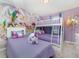 Unicorn-themed bedroom featuring a lofted twin bed, plush decorations, and colorful wall art at 1820 Summer Dr, Davenport, FL 33897