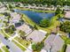An aerial view shows a home with a pool surrounded by lush landscaping and a serene community pond at 212 Tavestock Loop, Winter Springs, FL 32708