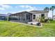 A charming backyard with a screened lanai, manicured lawn, and colorful flower beds enhances outdoor living at 212 Tavestock Loop, Winter Springs, FL 32708