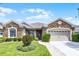 Charming single-story home with stone accents, well-manicured landscaping, and a two-car garage at 212 Tavestock Loop, Winter Springs, FL 32708