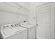 Functional laundry room equipped with a Whirlpool washer, dryer, and storage shelves at 212 Tavestock Loop, Winter Springs, FL 32708