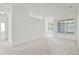 Open concept living area with neutral carpet, white walls, arched doorways, and natural light at 212 Tavestock Loop, Winter Springs, FL 32708