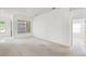 Open living area with carpet, white walls, an arched entryway, and large windows for natural light at 212 Tavestock Loop, Winter Springs, FL 32708