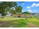 A spacious backyard with a green lawn and mature trees at 2213 Bates Ave, Eustis, FL 32726