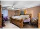 Bedroom features a neutral palette, ceiling fan, and large bed at 2213 Bates Ave, Eustis, FL 32726