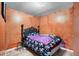 A quaint bedroom with plank flooring, dark headboard, and painted walls at 2213 Bates Ave, Eustis, FL 32726