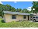 A cozy home exterior with green trim and mature trees in a relaxed neighborhood setting at 2213 Bates Ave, Eustis, FL 32726