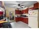 Traditional kitchen with red cabinetry and views to the dining area at 2213 Bates Ave, Eustis, FL 32726