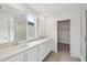 Bathroom featuring a double vanity, large mirrors, and a walk-in shower at 2467 Zuni Road, St Cloud, FL 34771