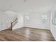 Spacious living room with hardwood floors, staircase, and plenty of natural light from large windows at 2467 Zuni Road, St Cloud, FL 34771