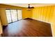 Bright living room features vertical plank accent wall, sliding glass doors, wood flooring, and a ceiling fan at 248 Crown Oaks Way, Longwood, FL 32779