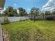 Backyard featuring a well-maintained lawn, a white fence, and mature trees at 2530 Baykal Dr, Kissimmee, FL 34746