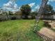View of the fenced backyard with green grass, trees, and plenty of natural light at 2530 Baykal Dr, Kissimmee, FL 34746