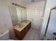 Bathroom with a double vanity, large mirror, toilet and a shower and tub at 2530 Baykal Dr, Kissimmee, FL 34746