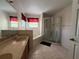 Bathroom featuring a double vanity, soaking tub, and glass enclosed shower at 2530 Baykal Dr, Kissimmee, FL 34746