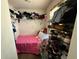 Small bedroom with a pink bedspread and closet filled with belongings, and a shoe rack at 2530 Baykal Dr, Kissimmee, FL 34746