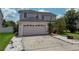 Two-story home featuring a two-car garage and walkway, with a green lawn and mature landscaping at 2530 Baykal Dr, Kissimmee, FL 34746
